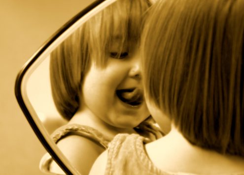 Child pulling a silly face in the mirror